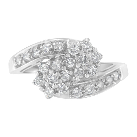 White metal ring with two clusters of round white gemstones in prong settings, shown in a close-up angled view.