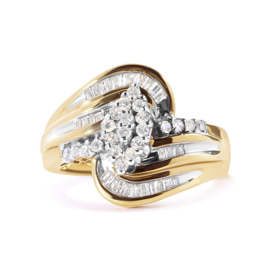 Yellow metal ring with overlapping design, featuring round white gemstones in prong settings clustered in the center and white baguette gemstones in channel settings along the band, shown in a close-up angled front view.