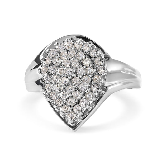 Close-up angled view of a white metal ring with numerous round white gemstones in a prong setting clustered on the top.
