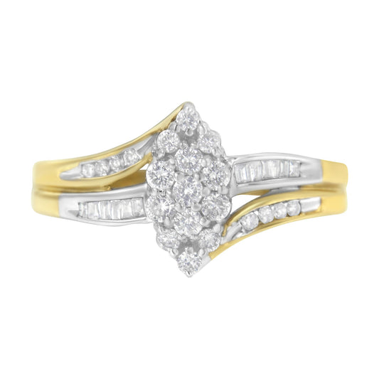 Front-facing close-up of a yellow and white metal ring featuring a cluster of round white gemstones in prong settings at the center, flanked by rows of baguette and round white gemstones in channel settings along the band.