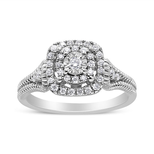 Front angle view of a white metal ring featuring a central round gemstone in a miracle setting, surrounded by multiple smaller round gemstones in prong settings forming a square halo, with additional small round gemstones along the split shank.
