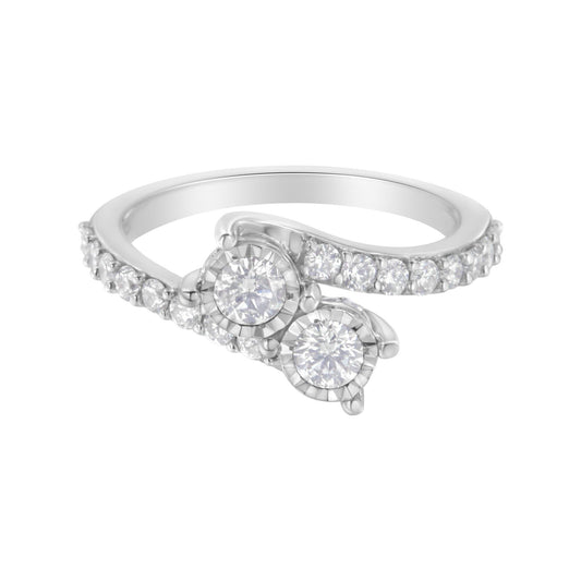White metal ring with two round white gemstones in miracle settings and multiple smaller round white gemstones in prong settings along the band, shown at a front angle.
