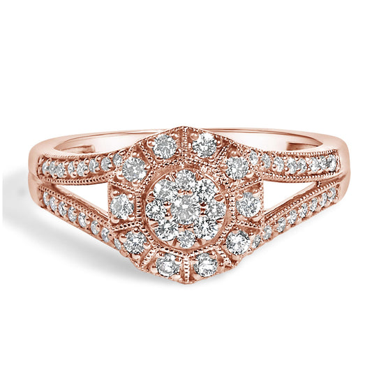 Close-up front view of a rose-colored ring with a hexagonal cluster of white round gemstones in pave setting, featuring additional white round gemstones along the split shank.