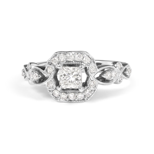 Front view of a white metal ring featuring a princess-shaped center white gemstone in a four-prong setting, surrounded by round white gemstones in a shared prong setting with intricate detailing on the band.