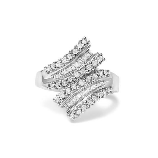 Close-up front angle of a white metal ring featuring multiple rows of round white gemstones in prong settings and baguette white gemstones in channel settings.
