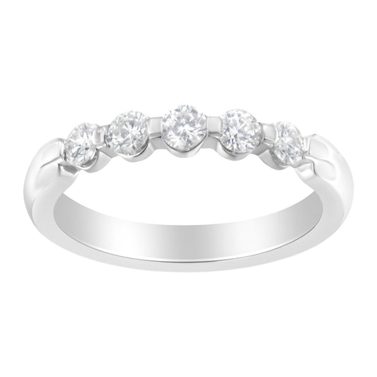 Close-up of a white metal ring with five round white gemstones set in a channel setting, shown from a front angle.
