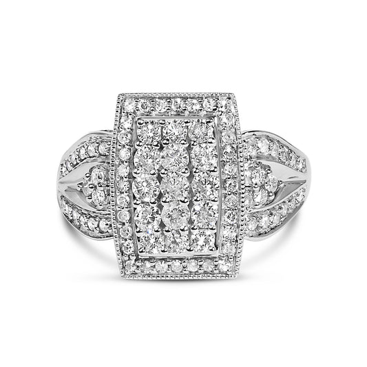 Top-down close-up of a white ring with a rectangular cluster of round white gemstones in a pave setting and additional gemstones on the band.