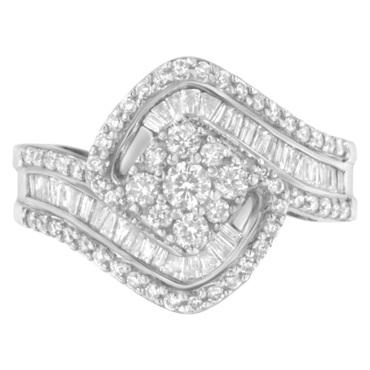 Close-up front angle of a white metal ring featuring cluster round white gemstones in prong settings surrounded by baguette and round white gemstones in channel and prong settings.