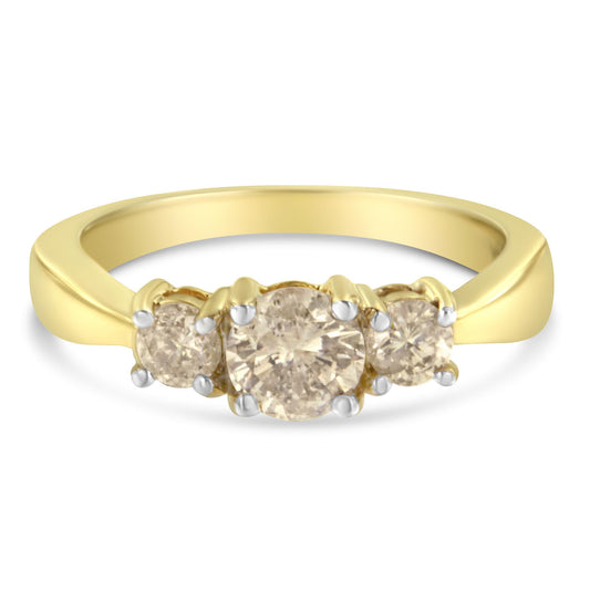 Front-facing view of a yellow metal ring with one larger round white gemstone in the center and two smaller round white gemstones on each side, all set in prong settings.