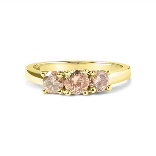 Front angle view of a yellow ring featuring a center round white gemstone with prong setting, flanked by two smaller round white gemstones also in prong settings.
