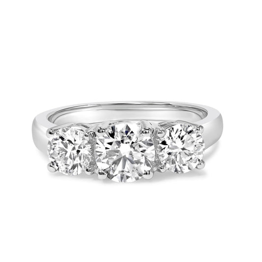 Front angle of white ring with three round white gemstones in prong settings, one larger center stone flanked by two smaller stones.