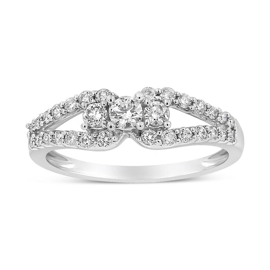 Front angle view of a white metal ring featuring a central round white gemstone in prong setting, flanked by smaller round white gemstones, with additional round white gemstones decorating the split band.