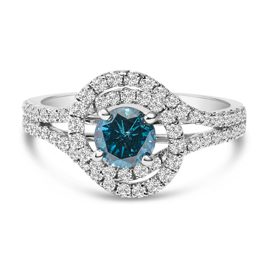 White metal ring with a central round blue gemstone in a prong setting, surrounded by two circular rows of small white gemstones, shown in a front close-up angle.