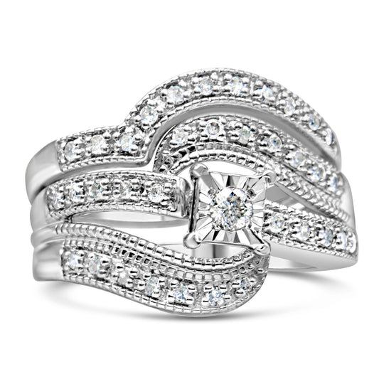 Close-up front angle of a white metal ring featuring one round white gemstone in a raised setting at the center, surrounded by multiple smaller round white gemstones in prong settings along the swirling band.
