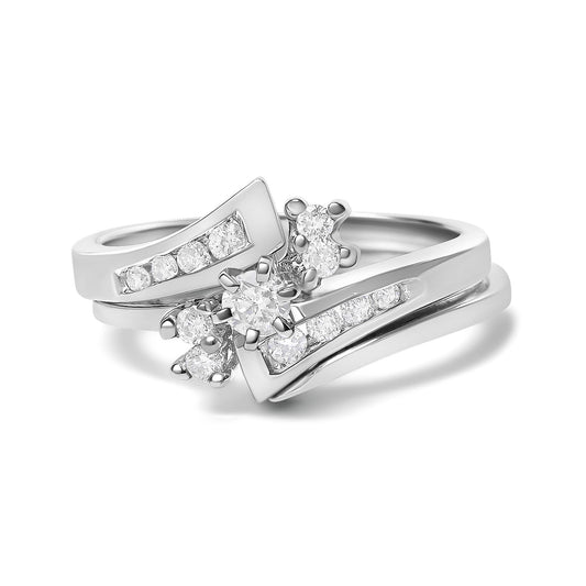 Close-up front angle of a white color ring featuring multiple round white gemstones in prong settings arranged in a decorative design.