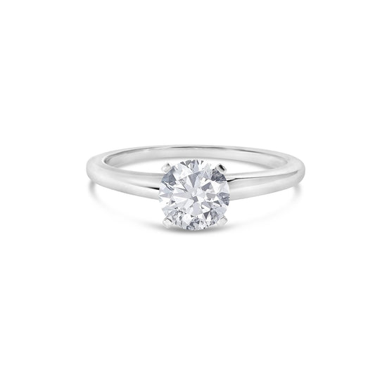 Front view of a white metal ring with a single round white gemstone in a four-prong setting.