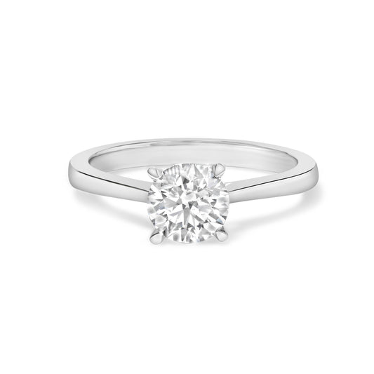 Front view of a white metal ring with a single round white gemstone in a four-prong setting.