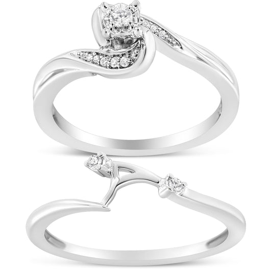 Two white metal rings shown in a close-up image, viewed from the top and side angles. The first ring features a central white gemstone in a prong setting, surrounded by multiple small white gemstones along a curved band. The second ring has a curved design with two small white gemstones in prong settings near the top.