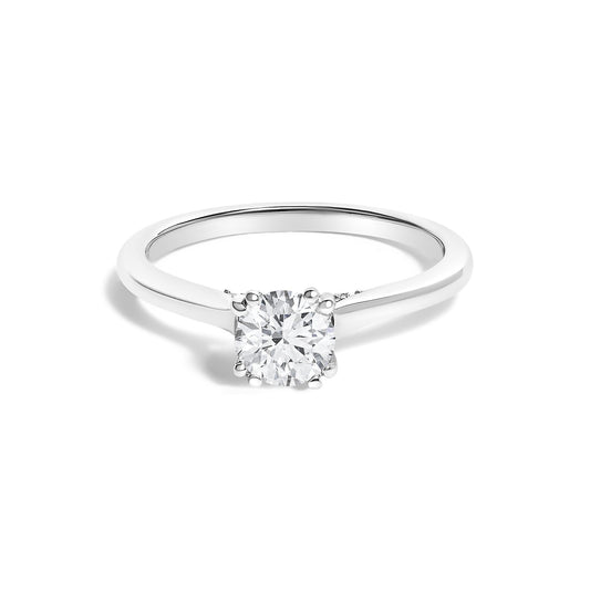 White-colored ring shown from a front angle featuring a round center white gemstone in a four-prong setting, flanked by smaller round white gemstones along the band.