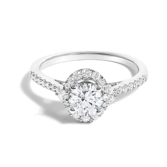 White metal ring with a large round red gemstone in a four-prong setting, surrounded by smaller white gemstones in a micro-pave setting, viewed from a front angle.