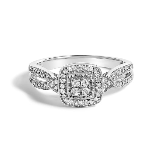 Close-up front angle of a white metal ring with multiple round white gemstones in prong settings arranged in a square cluster design and along the split band.