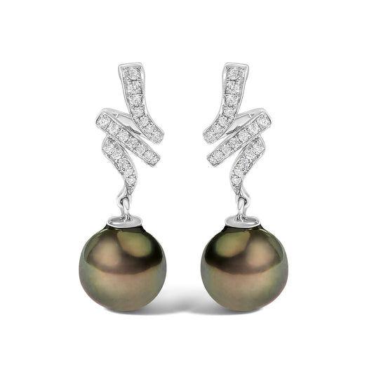 Front view of a pair of white metal earrings featuring a stylized curved design with micro-pave set round white gemstones on the upper part, and a single large dark-colored round pearl hanging from each.