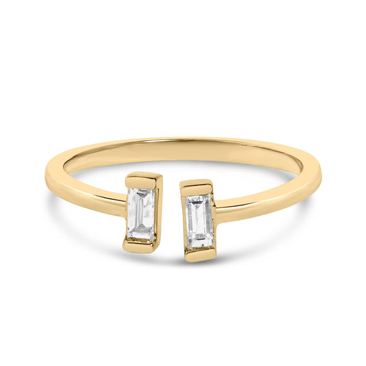 Close-up front angle of a yellow and white metal open ring featuring two white baguette-shaped gemstones in a channel setting.