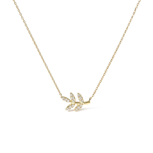 Yellow metal necklace with a small branch-shaped pendant adorned with white round gemstones in pave setting, photographed from the front on a white background.