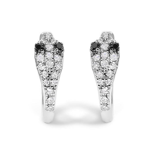 Front view of a pair of white metal earrings shaped like snakes, adorned with round white and black gemstones in prong settings.
