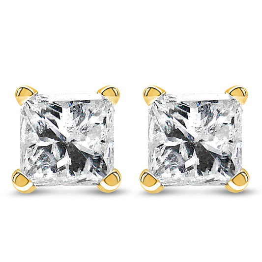 Front-facing close-up of a pair of yellow metal stud earrings each featuring a princess-shaped white gemstone in a four-prong setting.