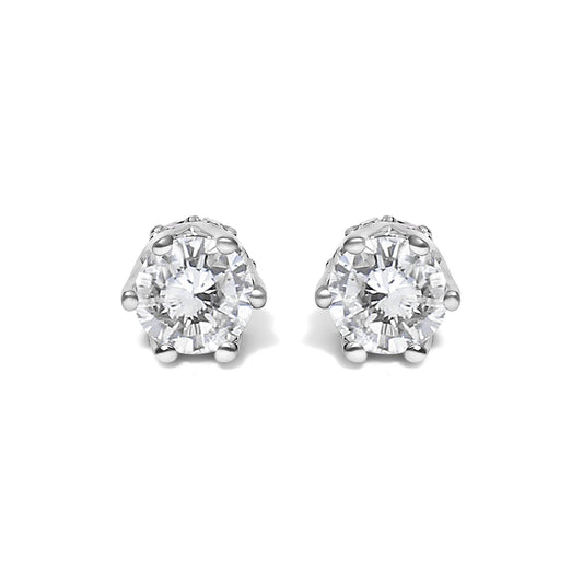 Front view of white stud earrings each featuring a round white gemstone in six-prong setting.