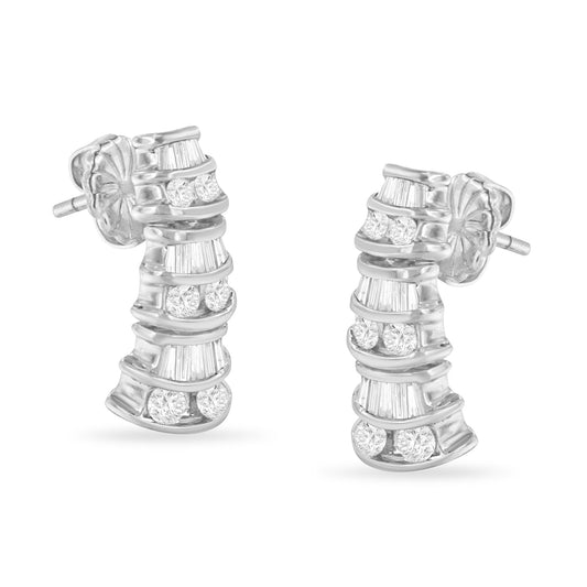 Pair of white metal earrings with curved design featuring channel set white round and baguette shaped gemstones, shown from a front angle.