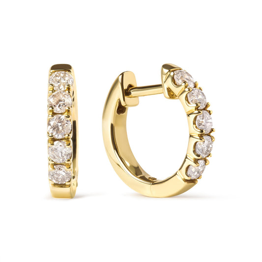 Close-up front and side view of a pair of yellow metal hoop earrings set with round white gemstones in prong settings.