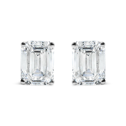 Pair of white metal earrings with emerald shaped white gemstones in 4-prong settings, front facing shot on white background.