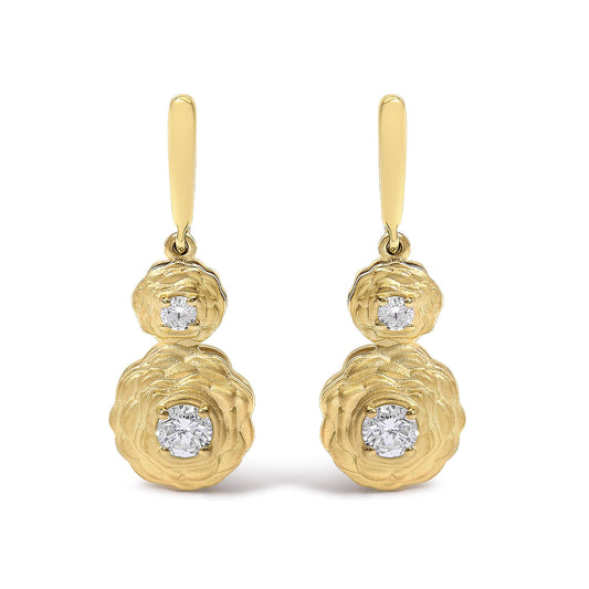 Front angle view of a pair of yellow metal drop earrings featuring two round white gemstones in 4-prong settings on each earring. The gemstones are set within textured floral-shaped elements, with a smaller flower on top and a larger flower below.