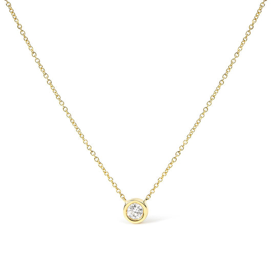 Front-facing shot of a yellow metal necklace with a round white gemstone in bezel setting pendant.