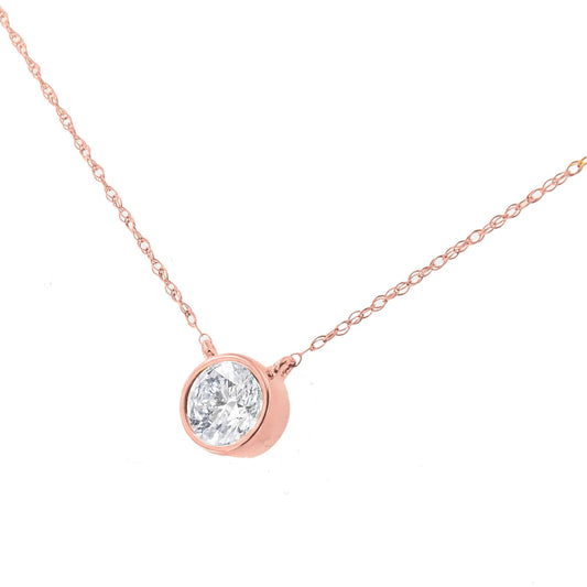 Close-up front angle of a rose metal necklace with a single round white gemstone in a bezel setting pendant.