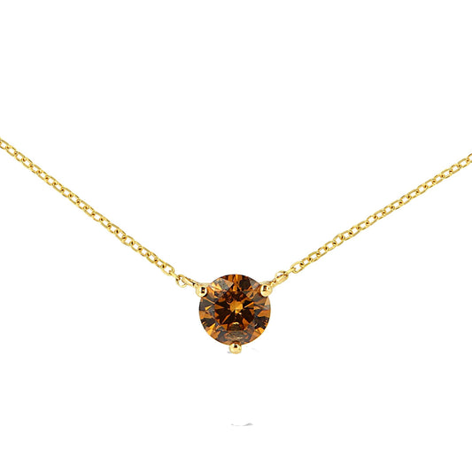 Close-up front view of a yellow metal necklace with a round red gemstone in a three-prong setting.