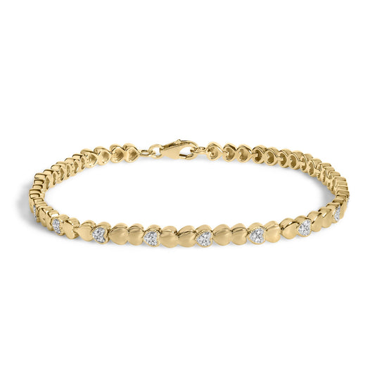 Yellow metal bracelet with heart-shaped links, some set with small white gemstones in a pave setting, shown in a close-up shot on a white background.