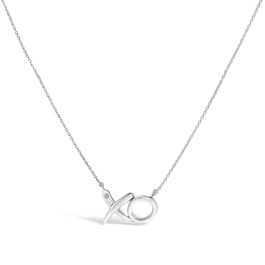 White necklace shown from the front with 'XO' shaped pendant featuring one round white gemstone in a bezel setting on the upper left part of the 'X'.