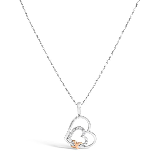 Close-up front angle of a white and rose metal necklace with a heart-shaped pendant featuring round white gemstones in a prong setting.