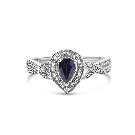 Front-facing view of a white metal ring with a pear-shaped blue gemstone center, surrounded by white round gemstones in a prong setting and an intricately detailed twisted band with more white round gemstones.