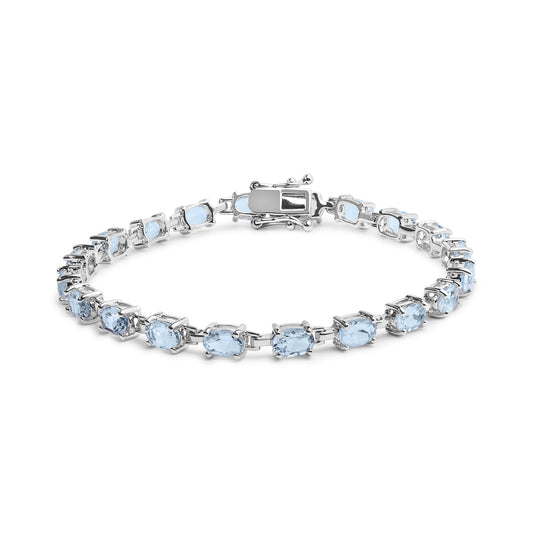 Close-up front angle of a white bracelet featuring oval-shaped blue gemstones in a prong setting.