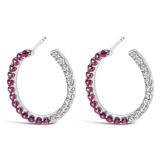 Close-up front view of white metal hoop earrings set with alternating red and white round gemstones in prong settings.