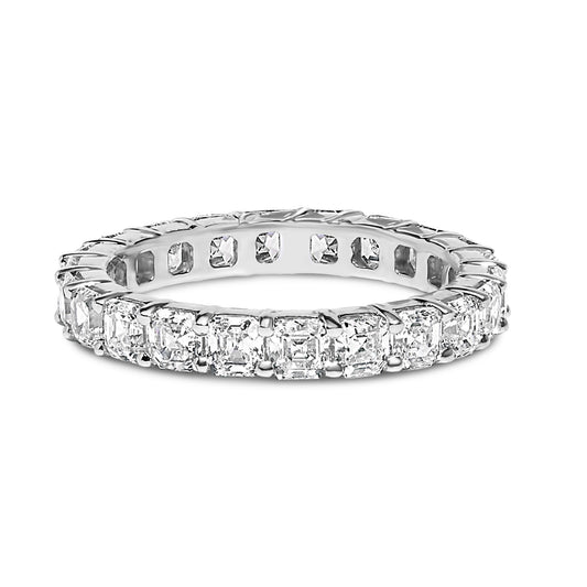 Close-up front angle view of a white metal ring featuring a continuous row of asscher-shaped white gemstones in a shared prong setting.