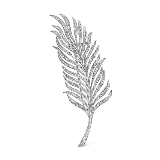 White metal brooch shaped like a stylized feather with curved sections paved with round white gemstones, shown at a slight angle on a white background.