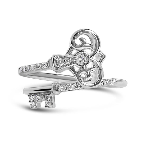 Close-up front angle of a white metal ring shaped like a key with embedded white round gemstones in prong settings along the band and key head.