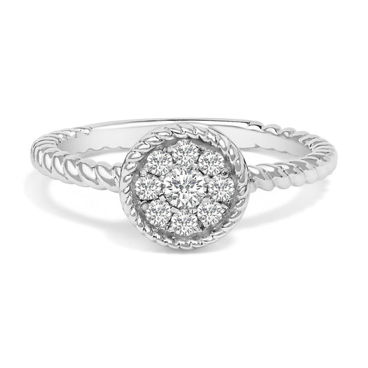 Close-up front angle of a white metal ring with a twisted band and a round cluster of white gemstones in a micro-pave setting.