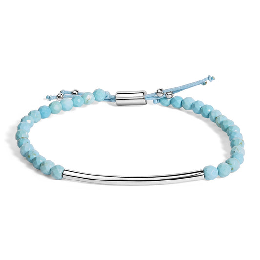 Bracelet with light blue faceted gemstones and a smooth curved white metal bar, shown flat from an overhead angle on a white background.