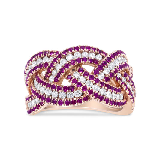 Front angled view of a rose metal ring with intertwined bands adorned with round white and red gemstones in prong settings.